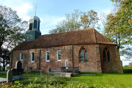 Church built in bricks next to a graveyard