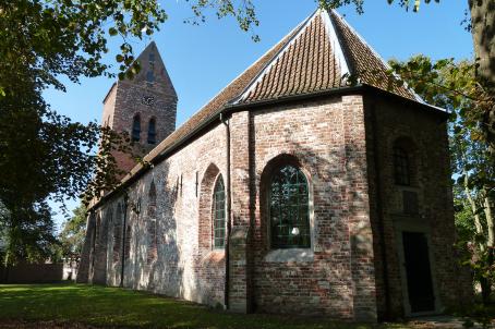 Backside of church built in bricks and annexed bell tower