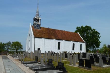 White church with red roof and cementery