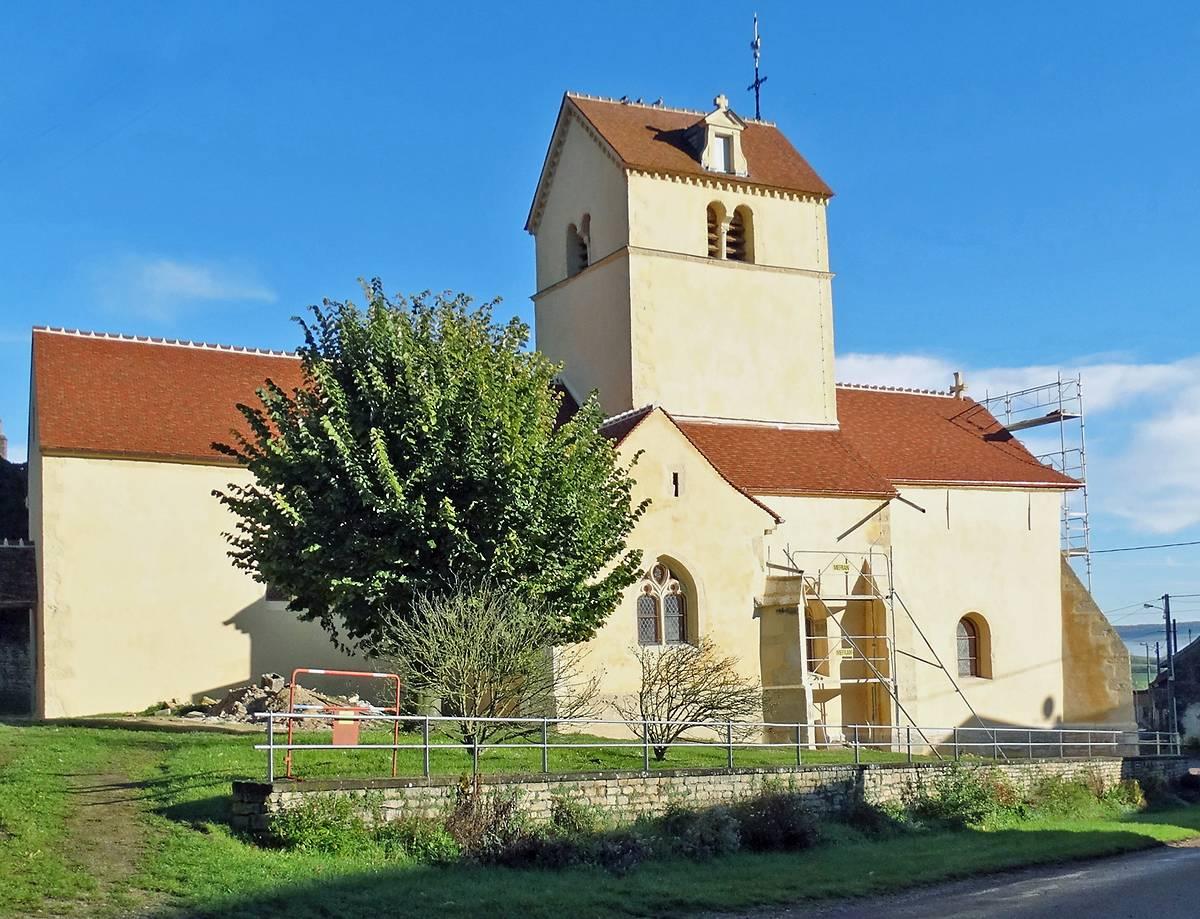 A white church with a tree 