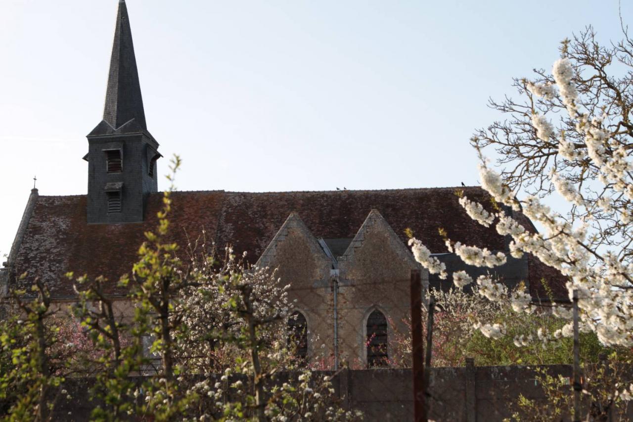 Church with a pointed pinnacle and blossom trees