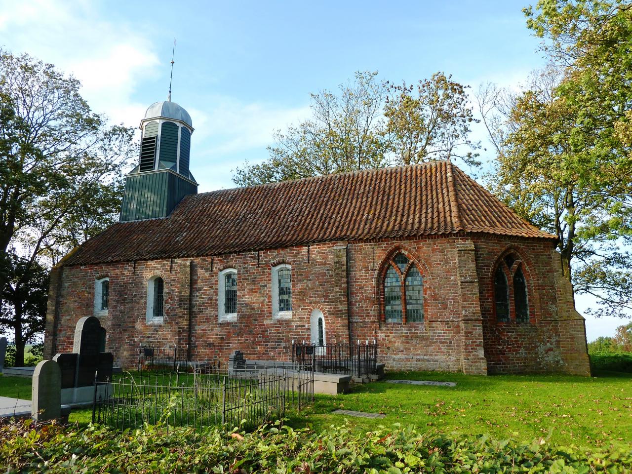 Church built in bricks next to a graveyard