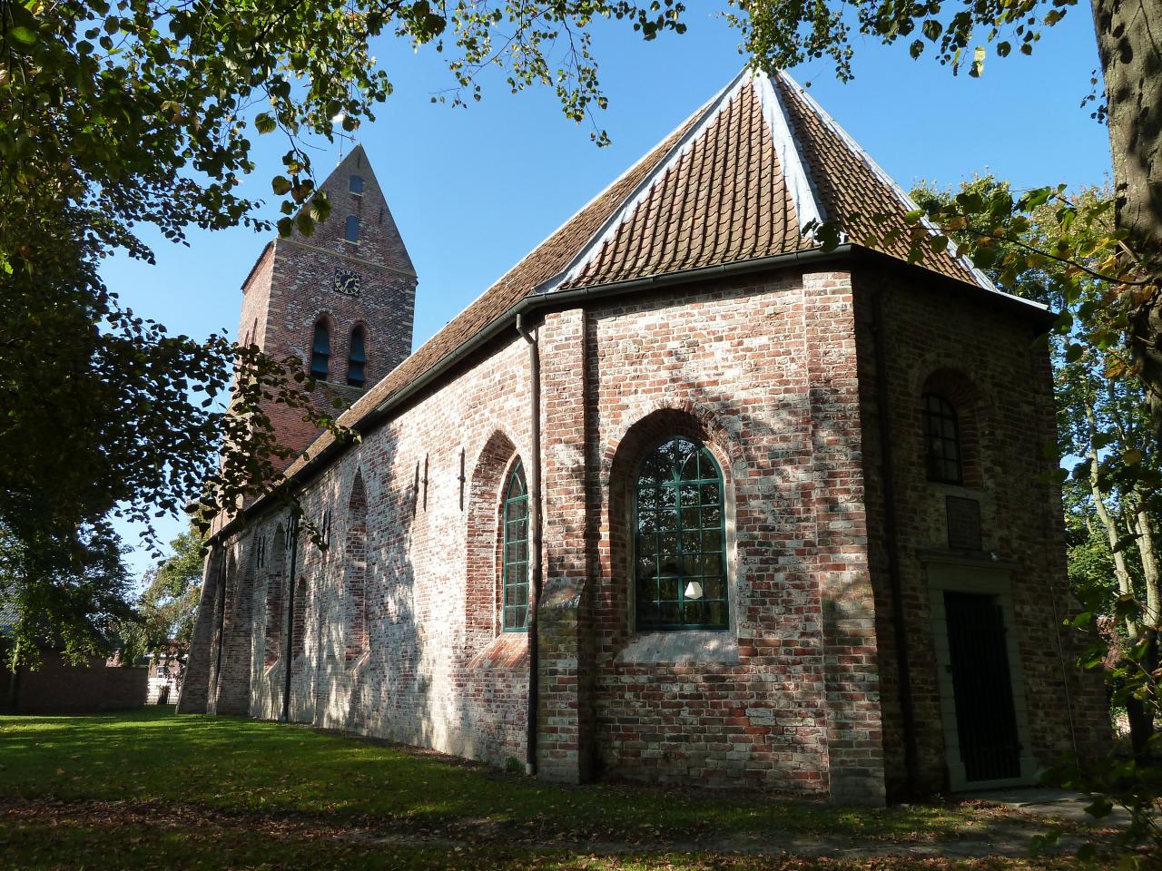 Backside of church built in bricks and annexed bell tower