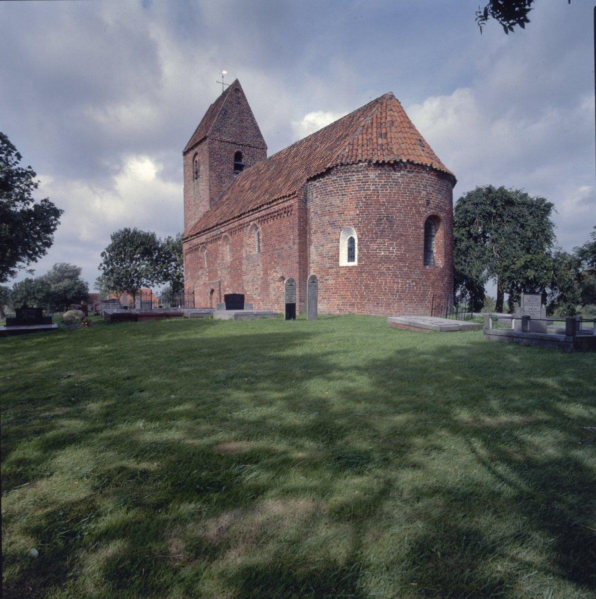 Brick church and graveyard in a field