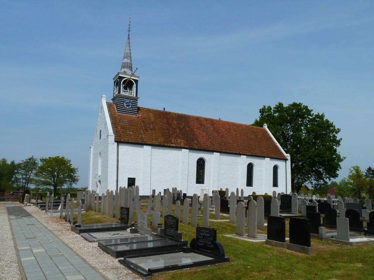 White church with red roof and cementery