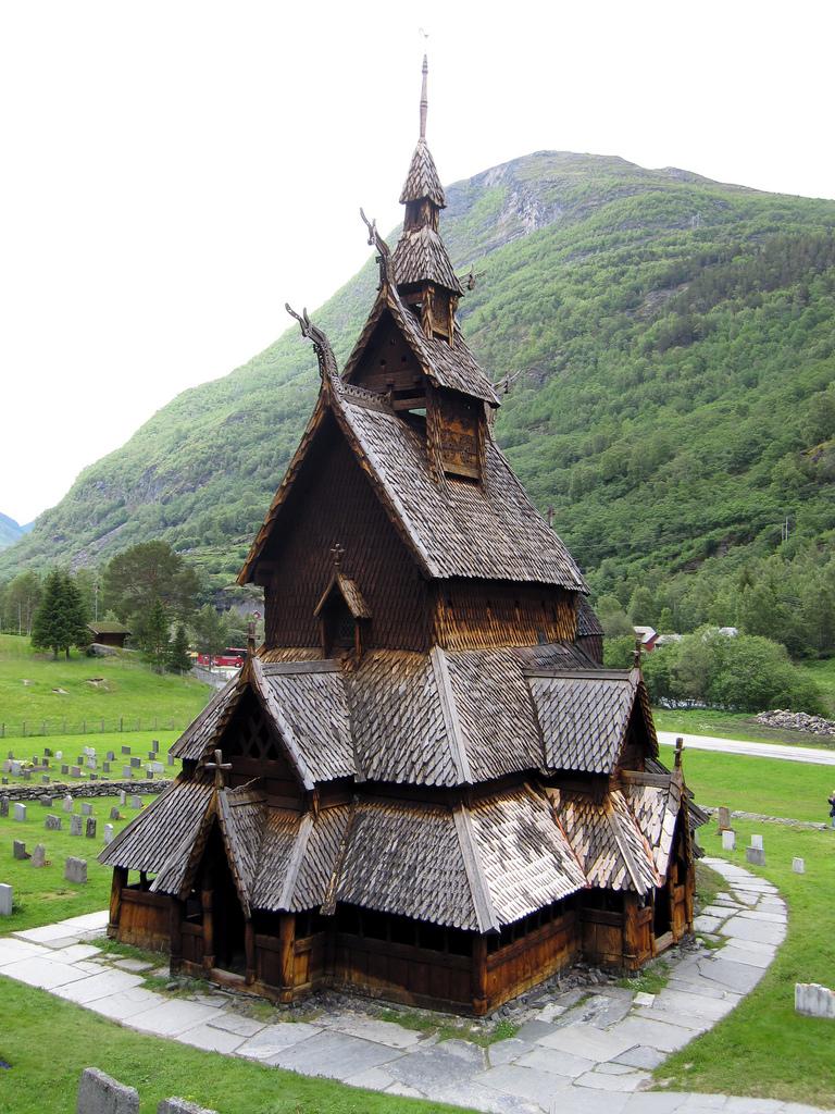 Stave church in front of a green hill