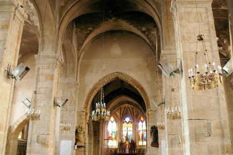 View of a church choir decorated with arches and golden chandeliers