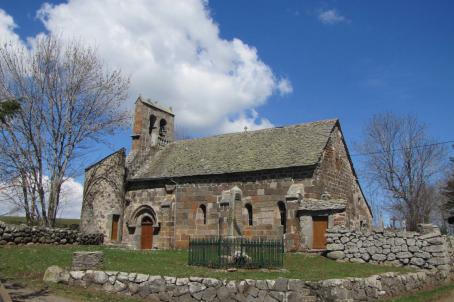 A church surrounded by fields and with clouds in the sky