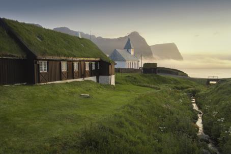 Church in front of a suggestive view of mountains and sea