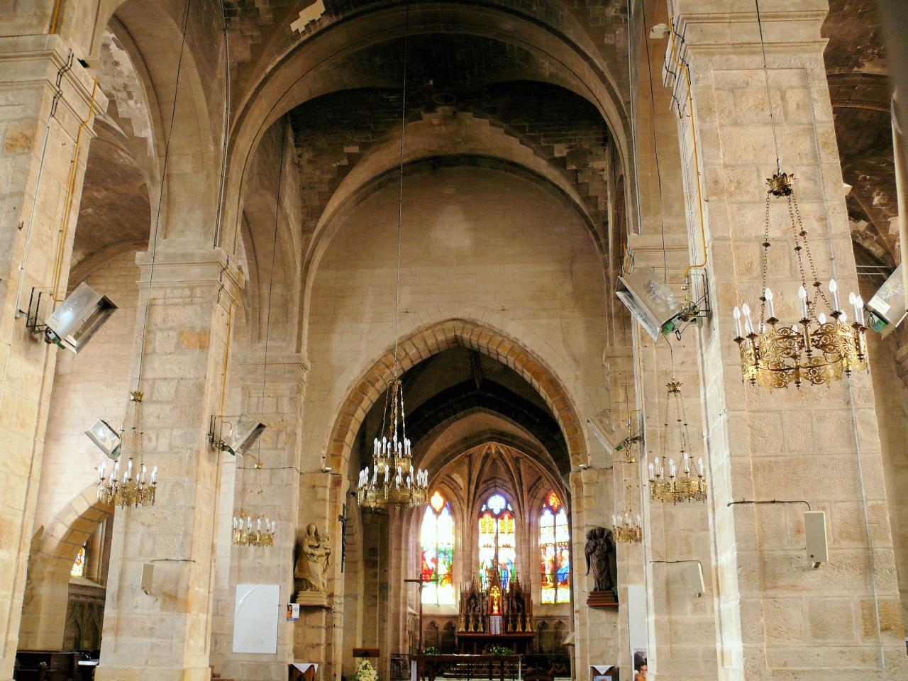 View of a church choir decorated with arches and golden chandeliers