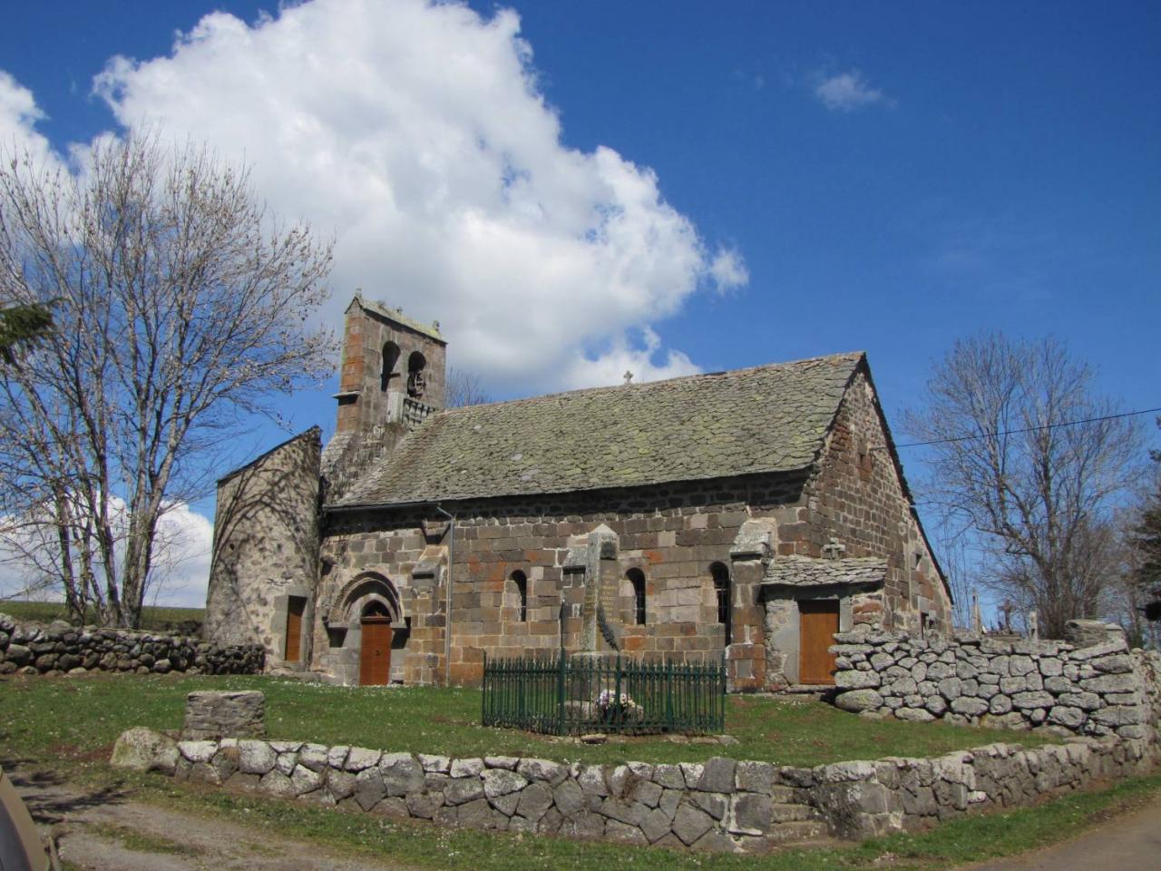 A church surrounded by fields and with clouds in the sky